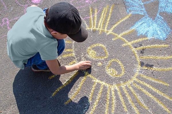 Un bambino sta giocando con un gesso nel parco giochi.
